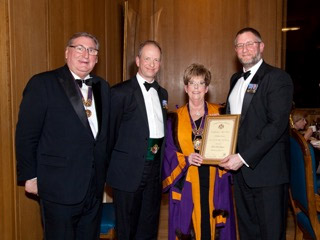 Lt Cdr. Simpson of HMS Queen Elizabeth, receiving his Award from the Master and Sponsor, Past Master John Harding